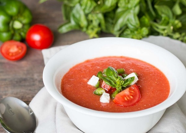 Холодный суп Гаспачо сервированный на тарелке вокруг с овощами